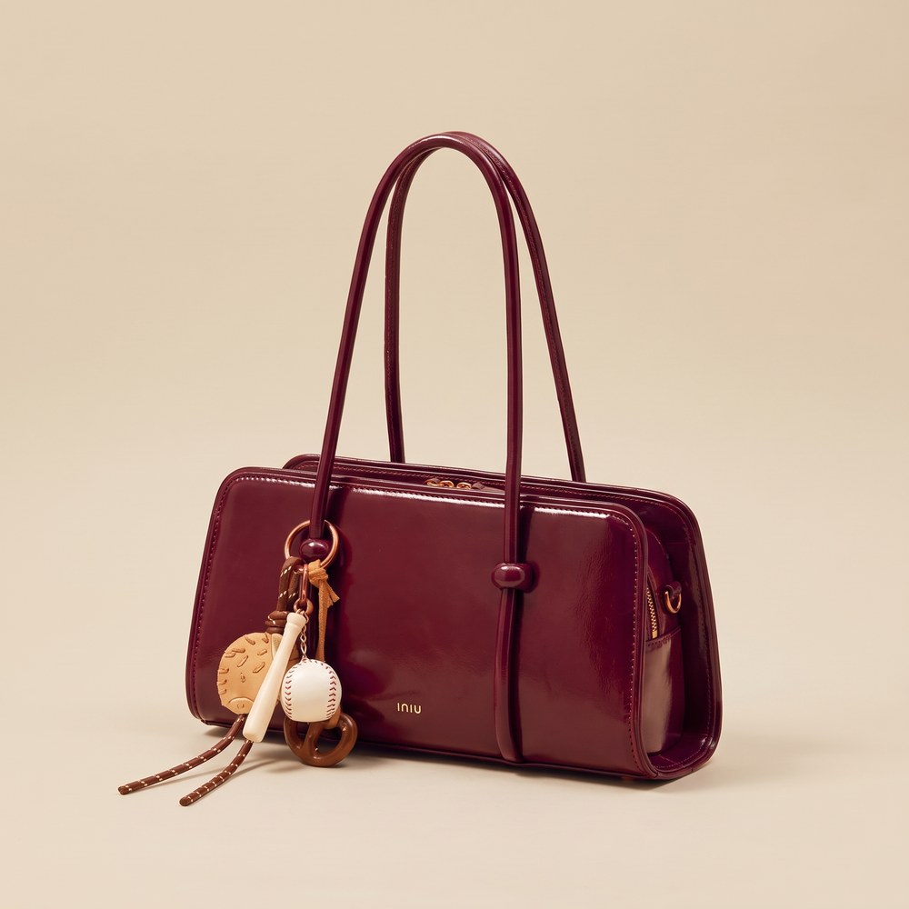 Burgundy leather shoulder bag with a tassel charm