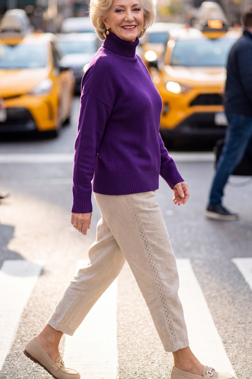Woman over 50 wearing a purple turtleneck with relaxed cream linen-style pants and loafers
